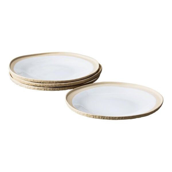 A stack of Nosse by Fortessa stoneware plates with gold rims on a white background.