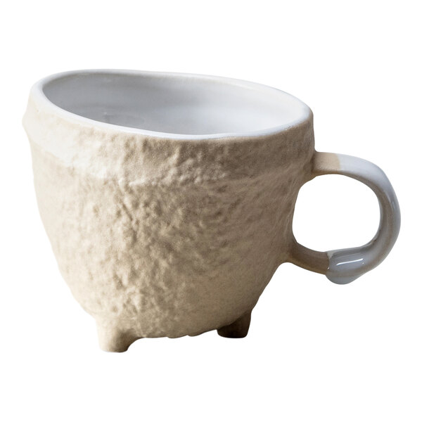 A white stoneware tea cup with a handle.