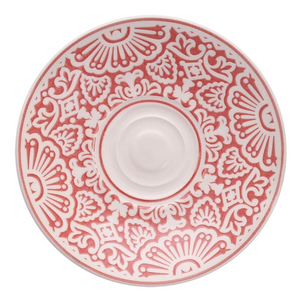 A white saucer with a pink and white design on it.