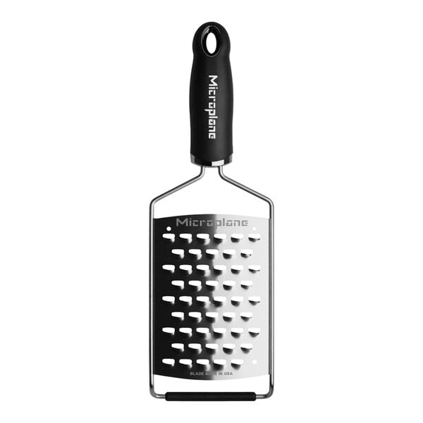 A close-up of a Microplane Gourmet black ultra-coarse grater with a white surface.