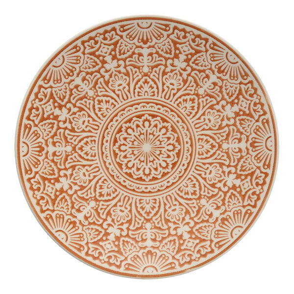 A Havana by Fortessa Adobo coupe plate with an orange and white pattern reminiscent of tiles.