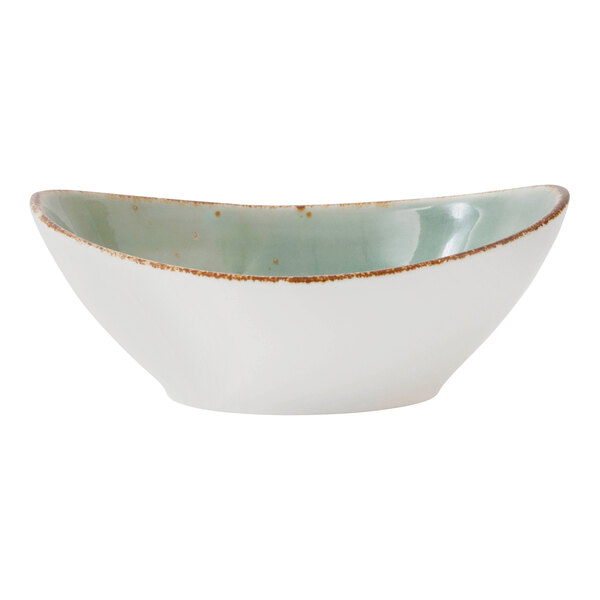 A white Erthe by Fortessa Basics oval bowl with a green speckled rim.