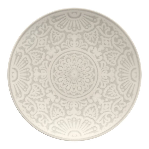 A close up of a white Havana by Fortessa coupe plate with a circular design on it.