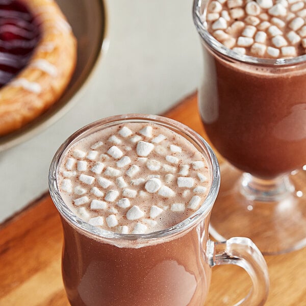 Two glasses of hot chocolate with Kraft Mini Vanilla Dehydrated Marshmallow Topping on top.