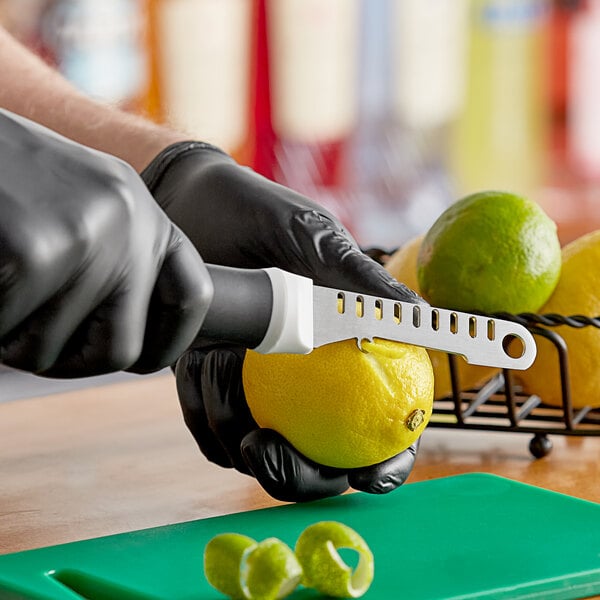 A person using a Microplane 7-in-1 Ultimate Bar Tool to peel a lemon.