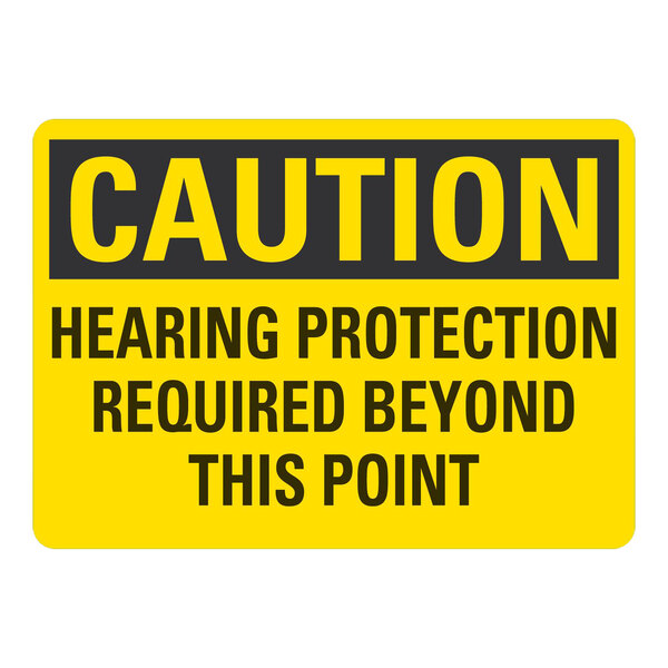 A yellow and black rectangular aluminum sign that says "Caution / Hearing Protection Required Beyond This Point"