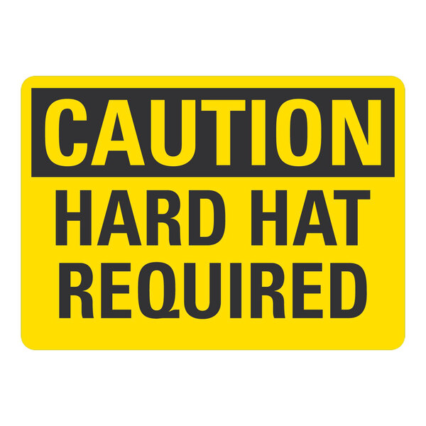 A yellow and black aluminum sign that says "Caution Hard Hat Required"