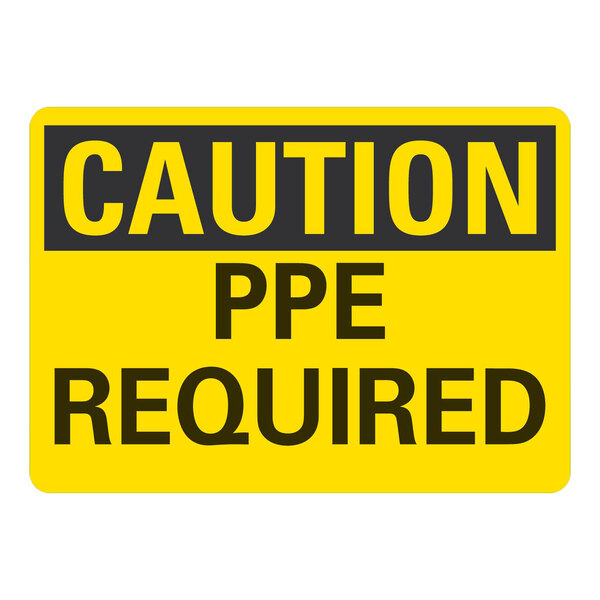 A yellow rectangular plastic sign with black text reading "Caution / PPE Required" 