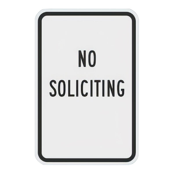 A white sign with black text that says "No Soliciting" in black letters.