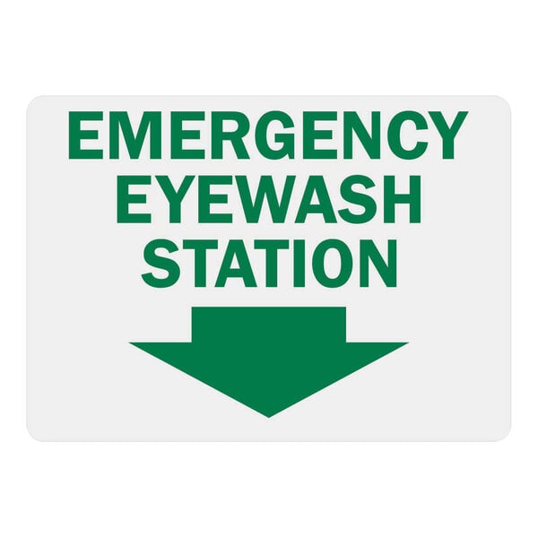 A white rectangular sign with green text reading "Emergency Eye Wash Station" and a green down arrow.