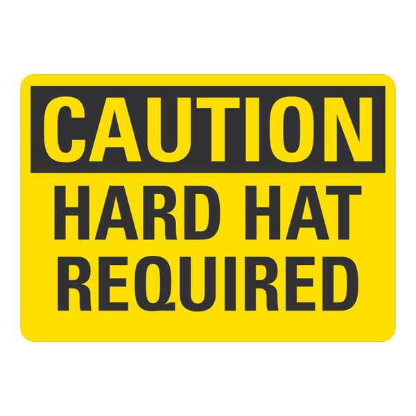 A yellow and black rectangular Lavex aluminum sign that says "Caution Hard Hat Required"