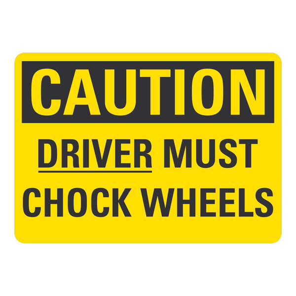 A yellow and black rectangular Lavex safety label with black text reading "Caution / Driver Must Chock Wheels"