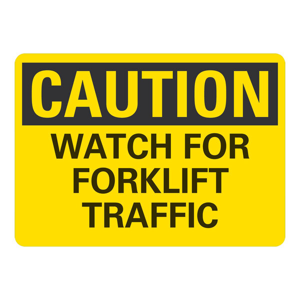 A yellow and black rectangular sign that says "Caution / Watch For Forklift Traffic" in black text.