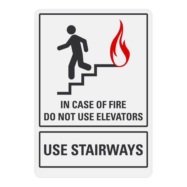 A white rectangular sign with black text that says "In Case of Fire Do Not Use Elevators" and a black silhouette of a person walking down stairs.