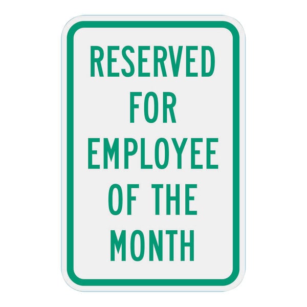 A white sign with green text that reads "Reserved For Employee Of The Month" in green.