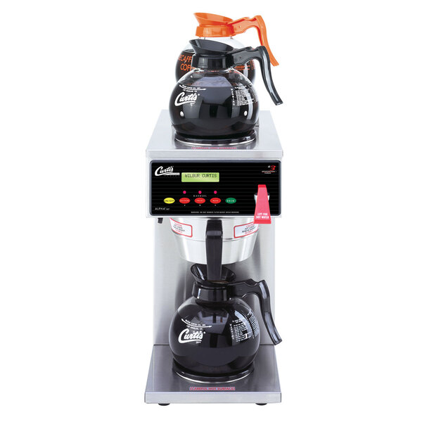 A Curtis automatic coffee maker on a counter with coffee pots underneath.