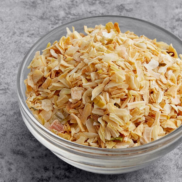 A bowl of McCormick Culinary Dehydrated Chopped Onion on a table.