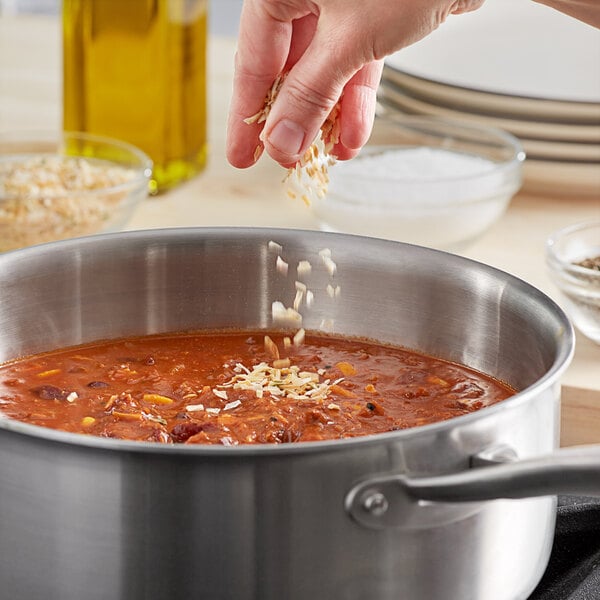 McCormick Culinary Dehydrated Chopped Onion being poured into a pot of food.