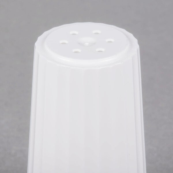 A white plastic salt shaker with holes in it.