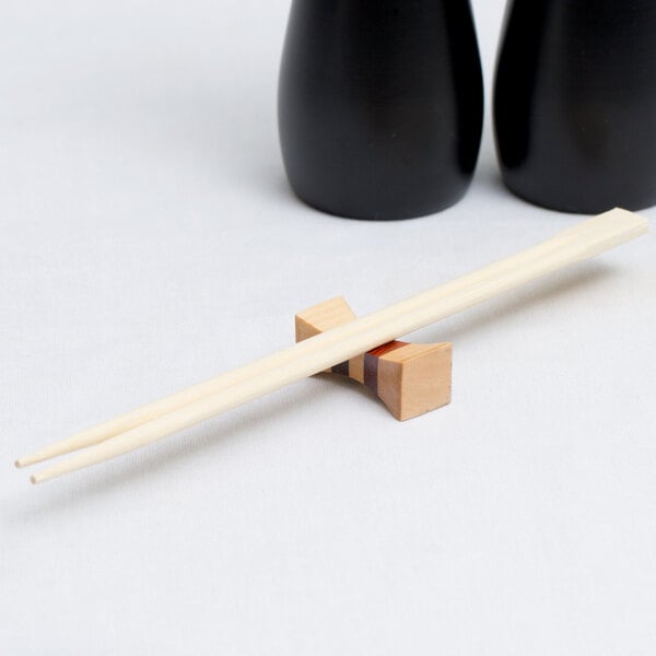 A pair of chopsticks on a Town hourglass chopstick rest.