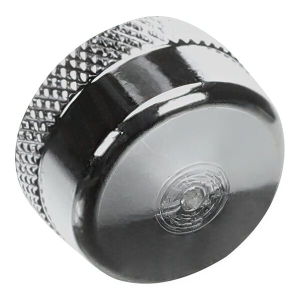 A close up of a silver knob with a black metal shield.