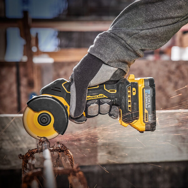 A person using a DeWalt compact cut-off tool to cut metal.