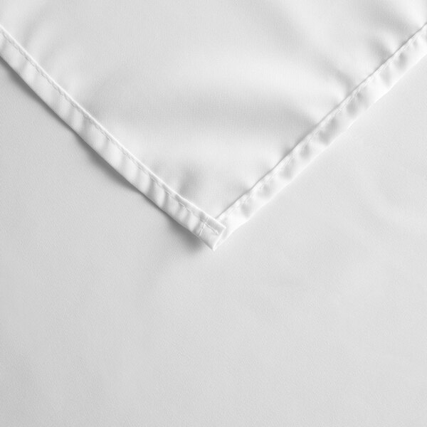 A white square Intedge table cover with a hemmed edge.