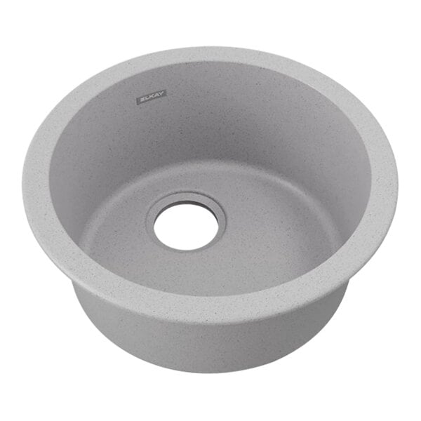 A greystone round quartz sink with a hole in the center.