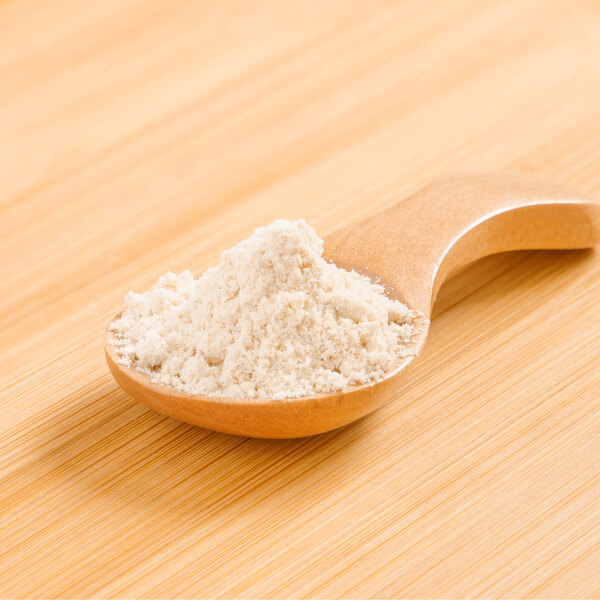 A wooden spoon holding Rainforest Supply Quinoa Powder.