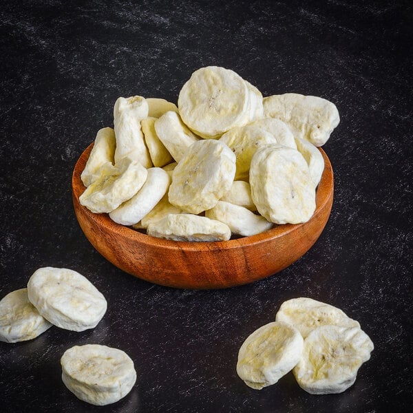 A wooden bowl filled with Rainforest Supply freeze-dried sliced bananas.