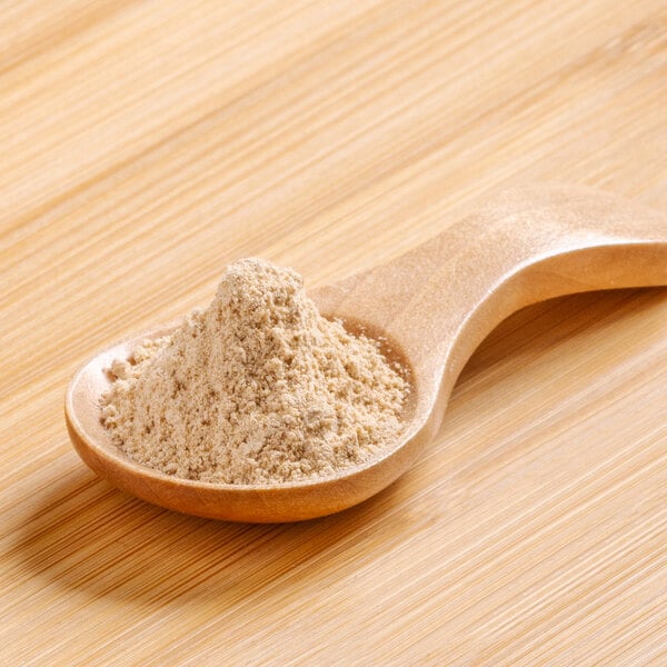 A wooden spoon full of Rainforest Supply Maca Powder.