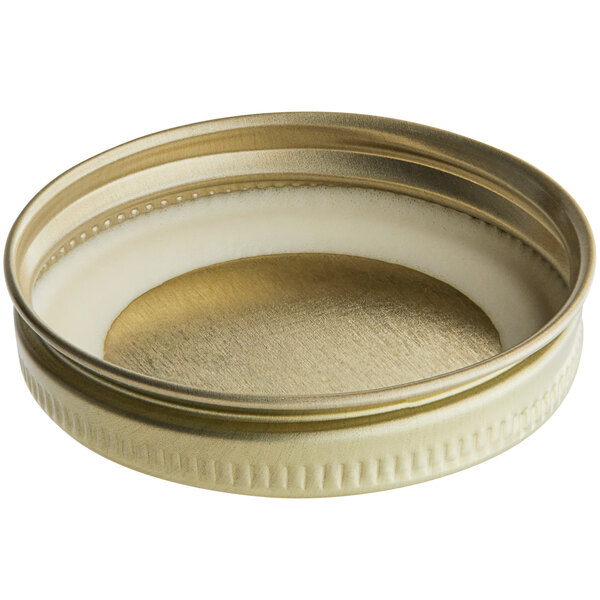 A close up of a 48/400 gold metal jar lid with a white plastisol liner.