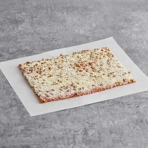 A rectangular piece of Tony's SMARTPIZZA Whole Grain Turkey Sausage Pizza on a white paper surface.