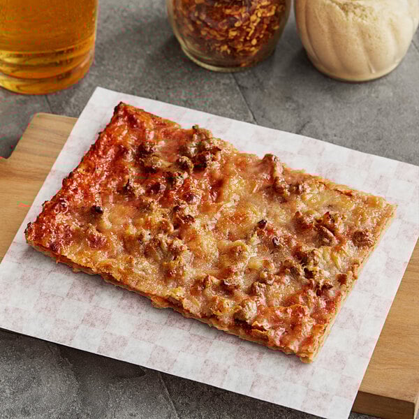A rectangular slice of Tony's SMARTPIZZA Whole Grain Turkey Sausage Pizza on a cutting board.