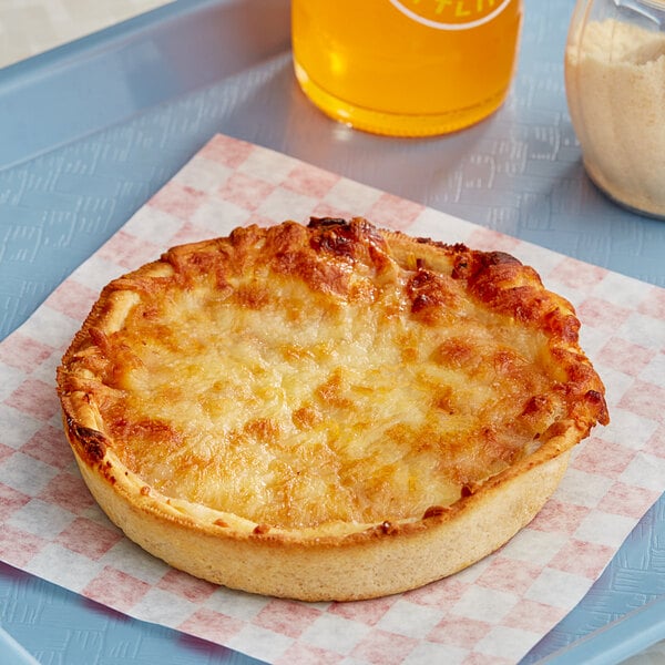 An individually wrapped Tony's cheese pizza on a checkered paper.