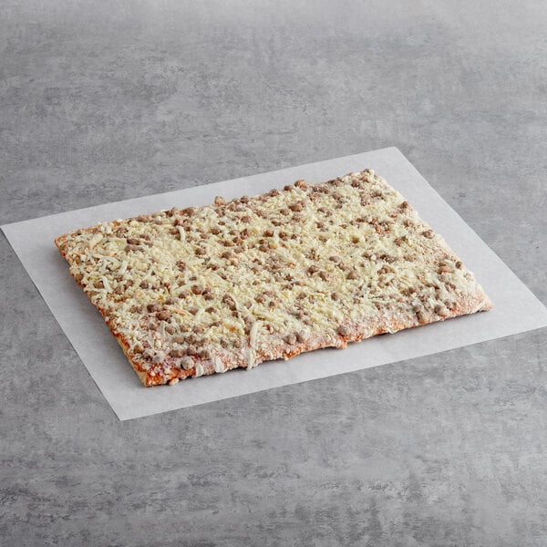 A rectangular piece of Tony's Whole Grain Turkey Sausage Breakfast Pizza on white paper.