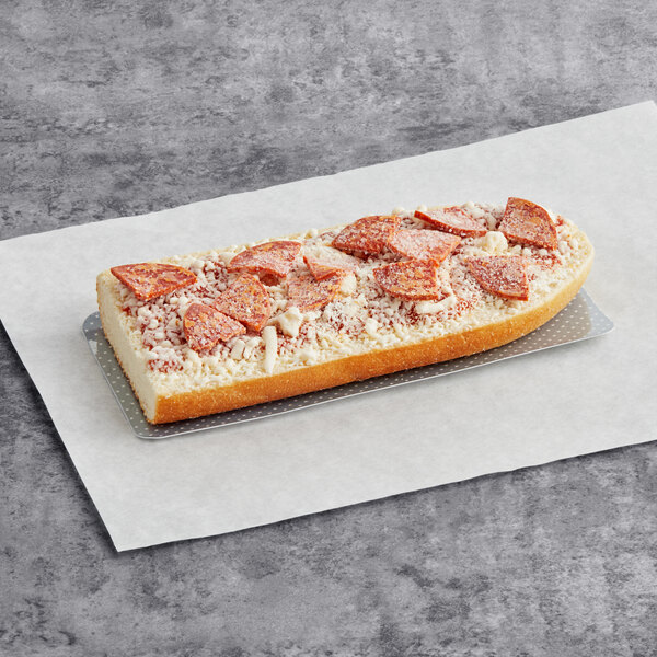 A long loaf of Red Baron French bread with pepperoni and cheese on top sitting on a paper.