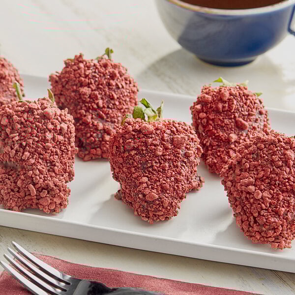A plate of strawberries with Yum Crumbs Red Velvet Topping on top.