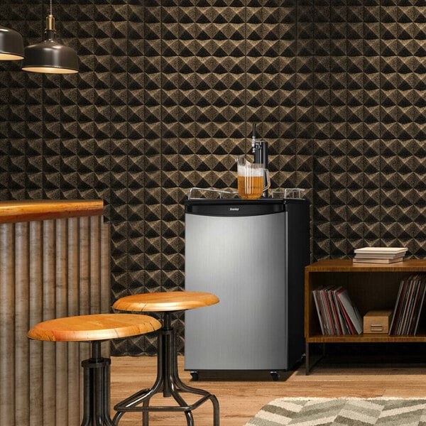 A Danby spotless steel beer dispenser with a tap on a round wooden table.