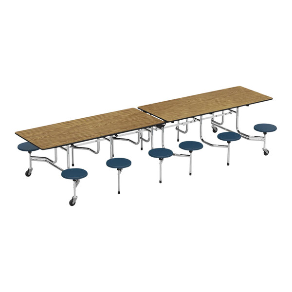 A medium oak rectangular cafeteria table with navy stools on silver poles.