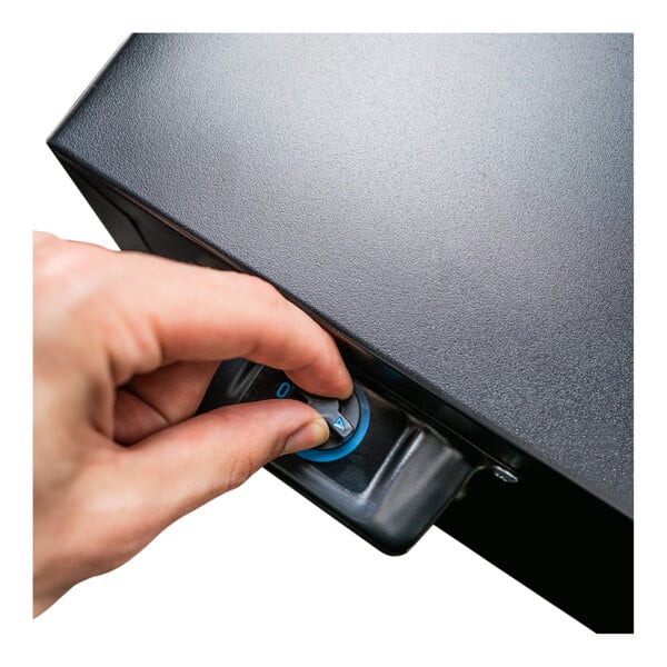 A hand turning the lock on a Danby stainless steel glass door beverage refrigerator.