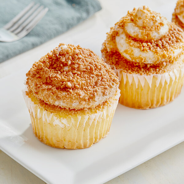 A cupcake with salted caramel crumb topping and sprinkles on a plate.