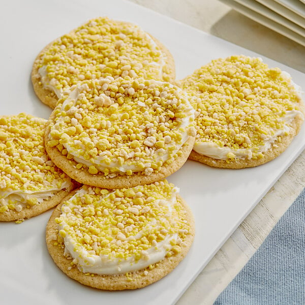 A plate of cookies with Yum Crumbs Banana Cream Pie topping on yellow frosting.