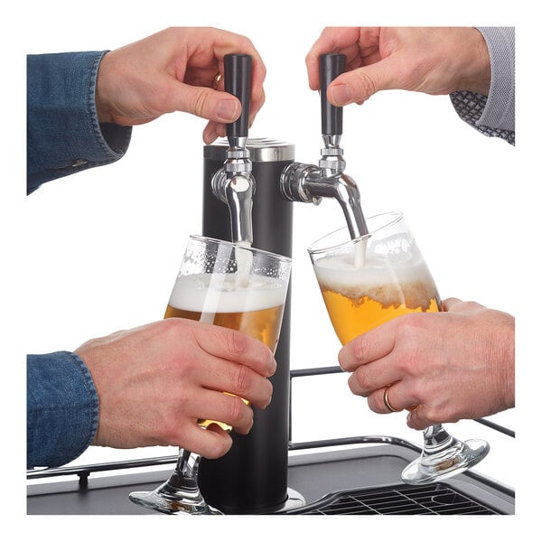 A hand pouring a glass of beer from a Danby kegerator.