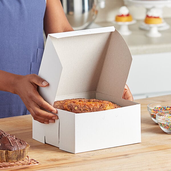 A woman opening a white Baker's Lane box of food.