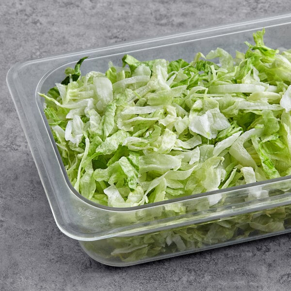 A container of shredded lettuce on a counter.
