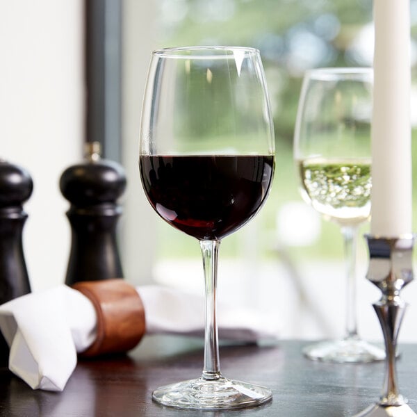 A Libbey Vina wine glass filled with red wine on a table.