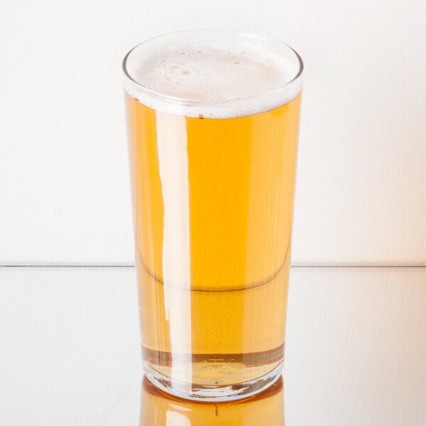 A Libbey Heavy Base cooler glass filled with beer on a table.