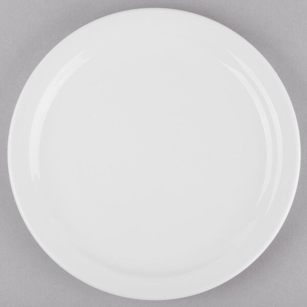 A Libbey Porcelana round white porcelain plate with a narrow white rim on a gray surface.