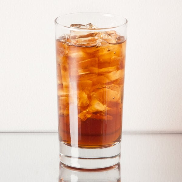 A Libbey beverage glass filled with brown liquid and ice.